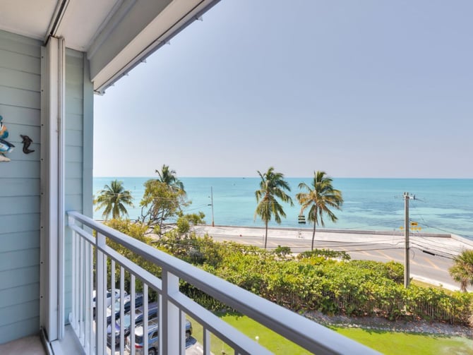 Balcony with turquoise ocean and palm tree view